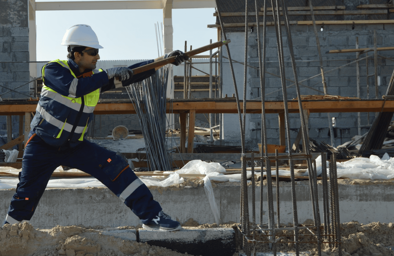 Stone Haven Developments A construction worker in safety gear uses a tool to work with steel reinforcement bars at a building site. Ontario
