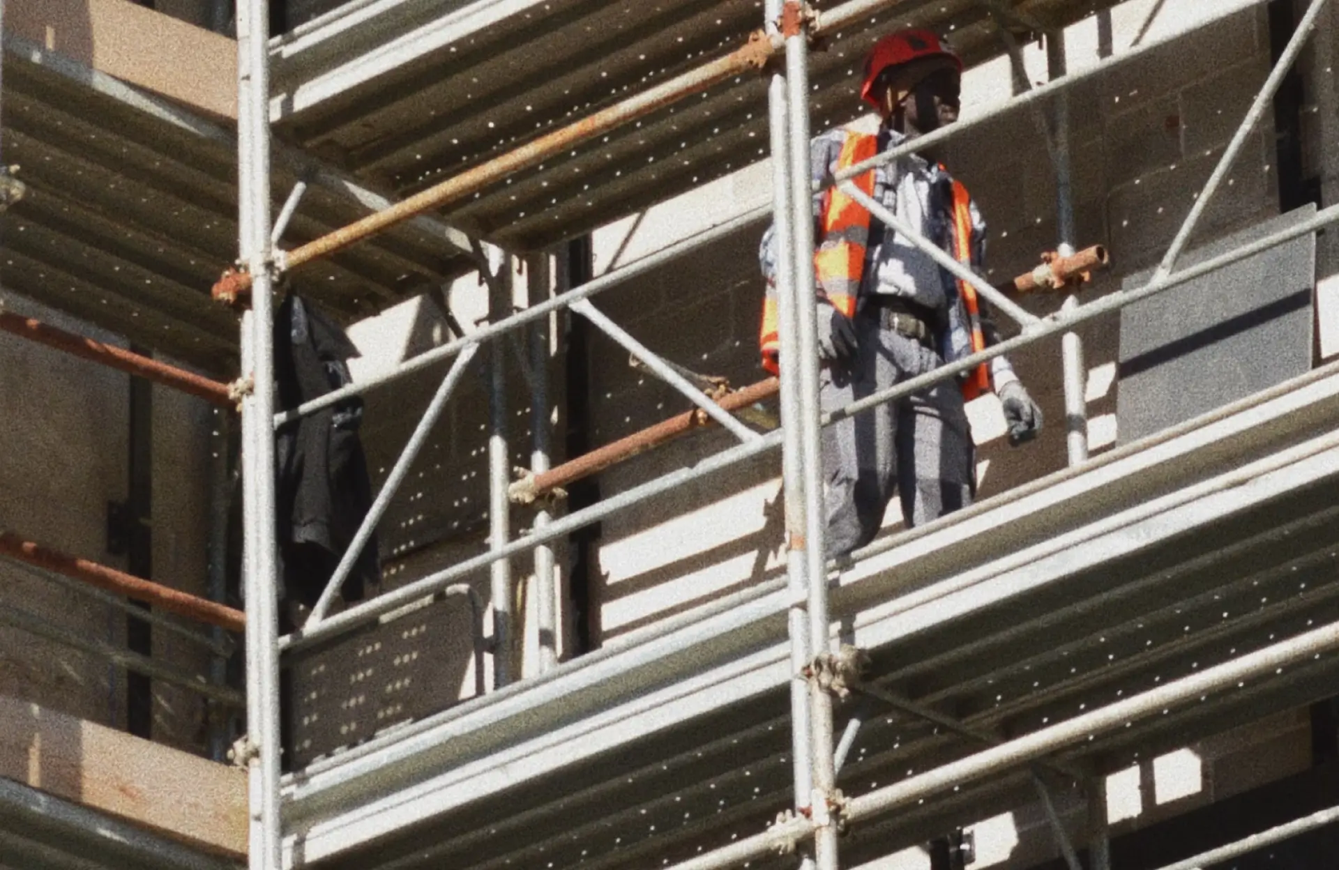 Stone Haven Developments Two construction workers wearing safety gear stand on metal scaffolding next to a building under construction. Ontario