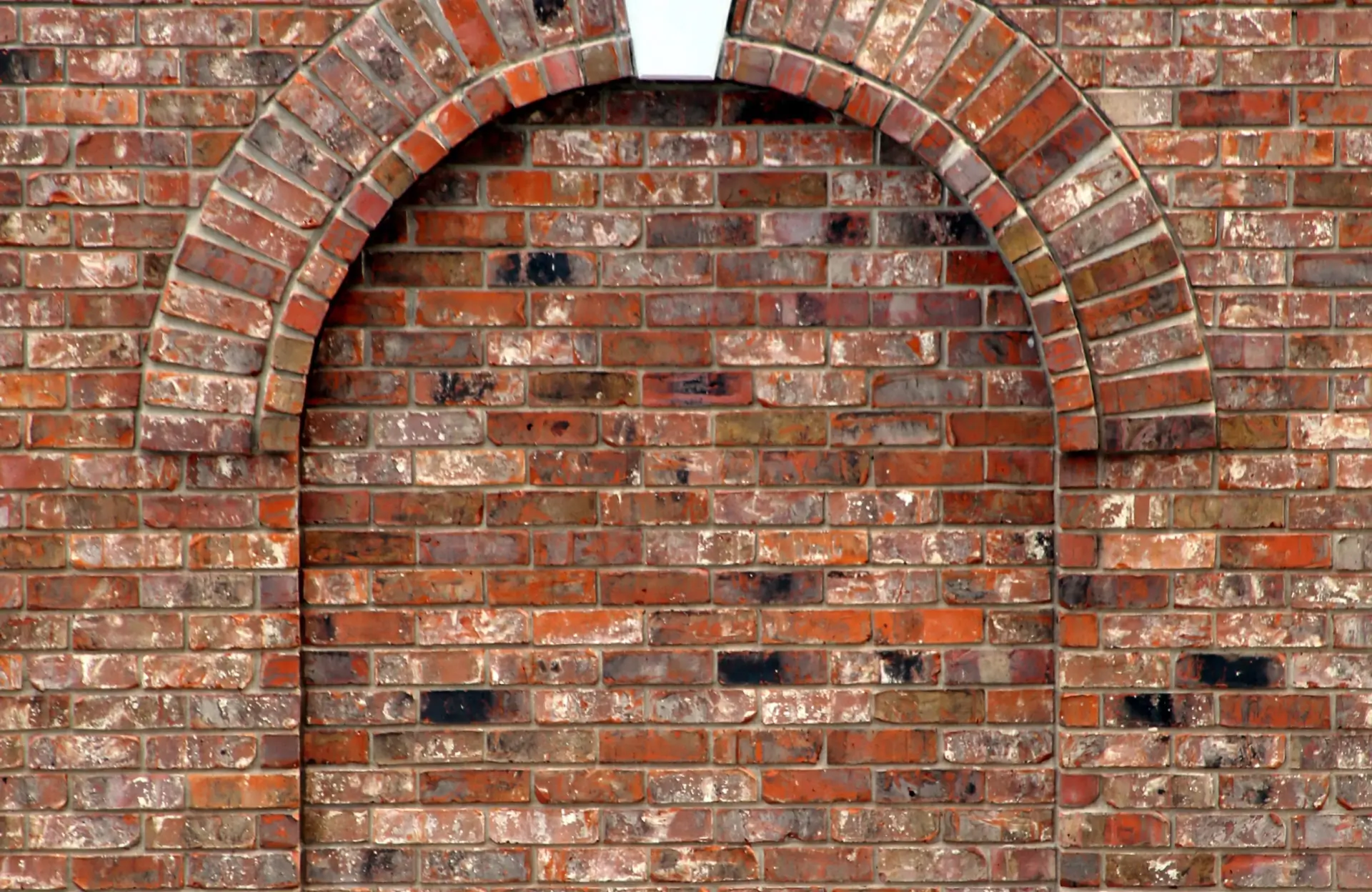 Stone Haven Developments A brick wall with a decorative archway structure; the arch is filled in with matching bricks, forming a solid surface. Ontario
