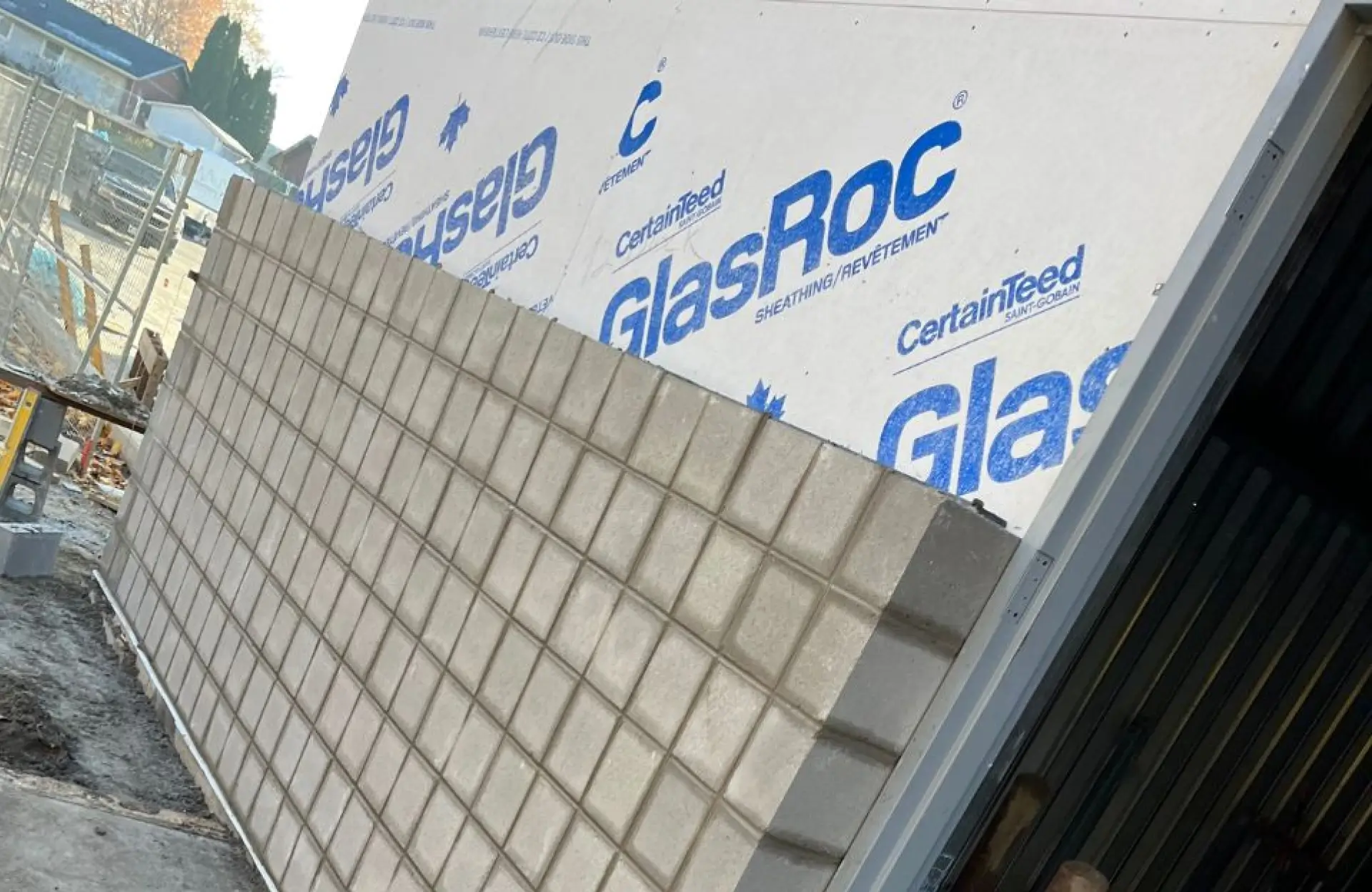 Stone Haven Developments A partially constructed wall with concrete blocks and GlasRoc sheathing panels visible at a building site. Ontario