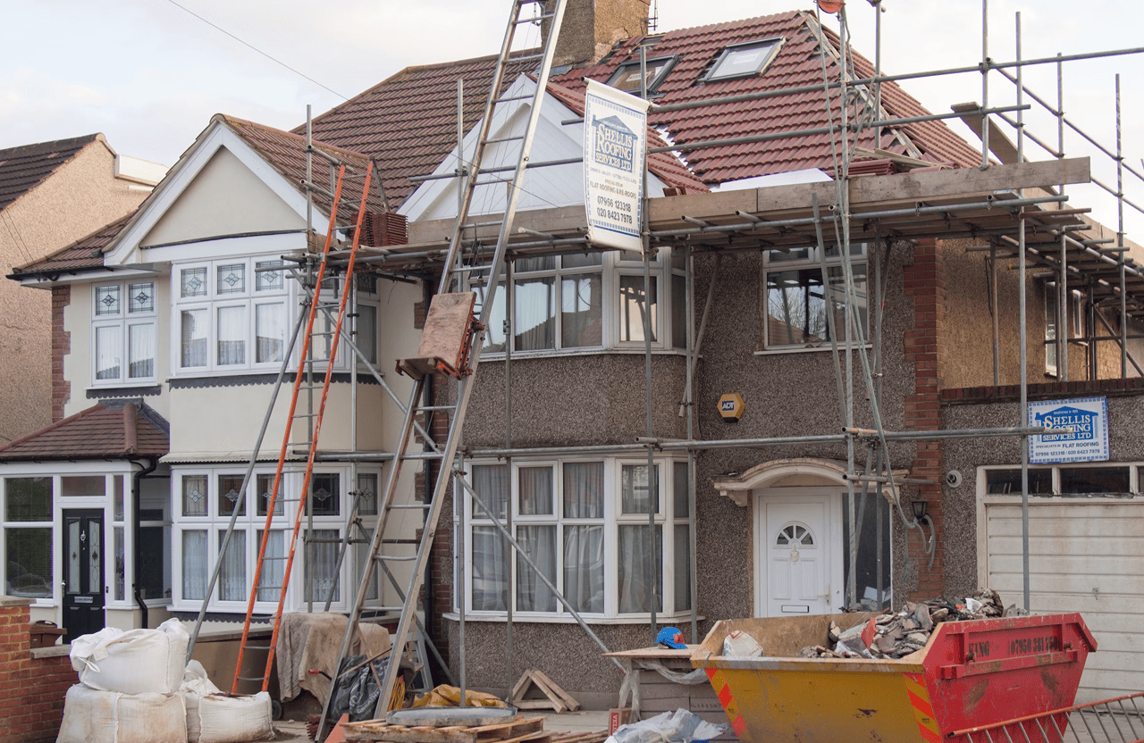 Stone Haven Developments A house under construction with scaffolding, ladders, building materials, and a skip in front; roof and windows are being renovated. Ontario