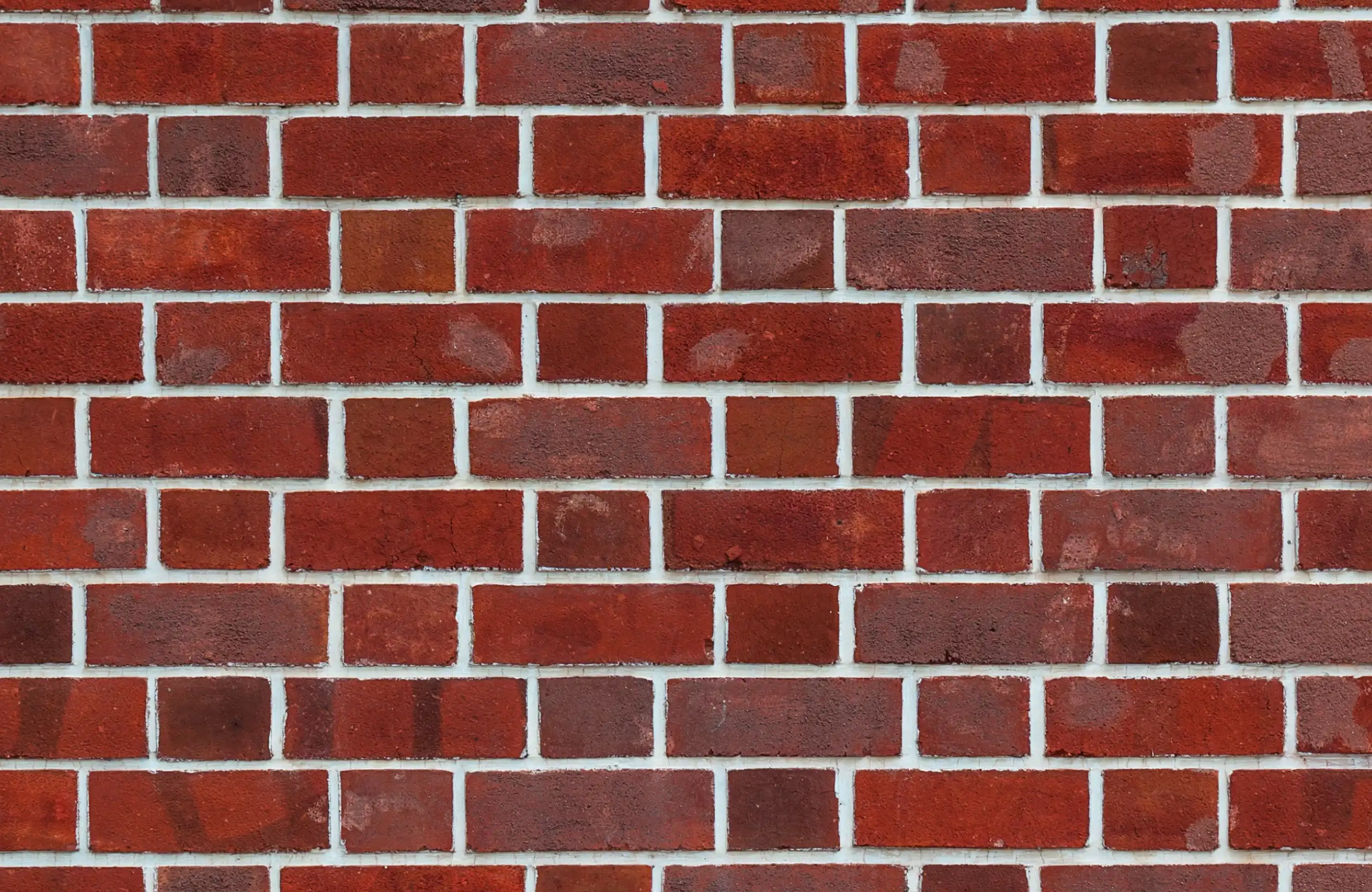 Stone Haven Developments A close-up view of a red brick wall with white mortar lines in a horizontal, staggered pattern. Ontario